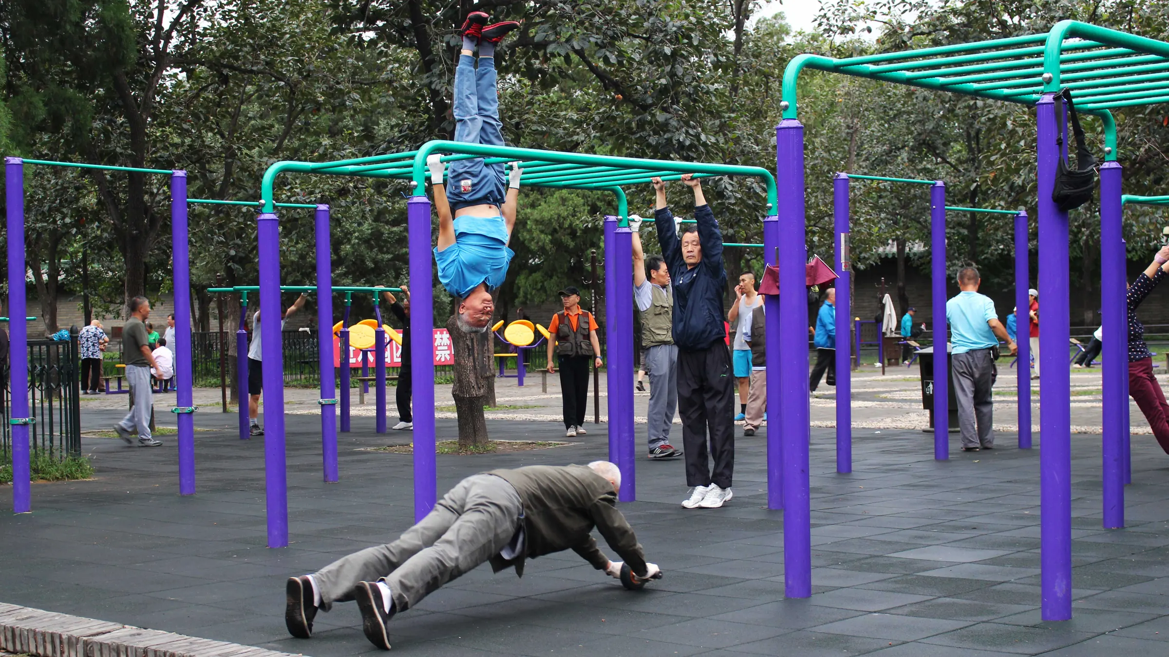 Older men exercising on outdoor bars in a park